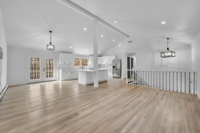 unfurnished living room with light hardwood / wood-style flooring, beamed ceiling, french doors, and high vaulted ceiling