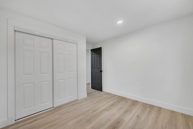 unfurnished bedroom featuring a closet and light wood-type flooring