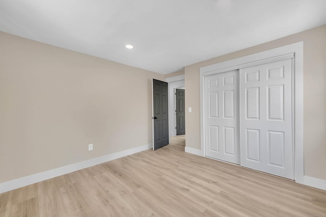 unfurnished bedroom with a closet and light hardwood / wood-style flooring