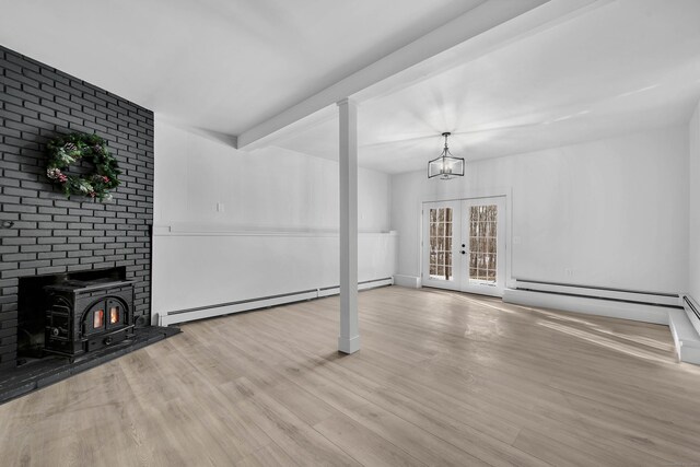 unfurnished living room featuring a wood stove, french doors, light hardwood / wood-style flooring, a baseboard radiator, and beam ceiling