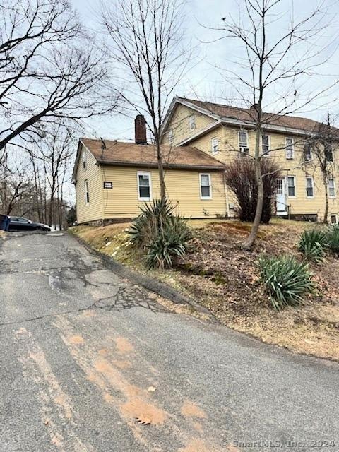 view of front of home with aphalt driveway and a chimney