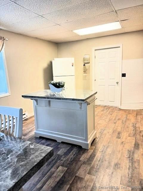 kitchen featuring a paneled ceiling, white cabinetry, dark hardwood / wood-style floors, and white refrigerator