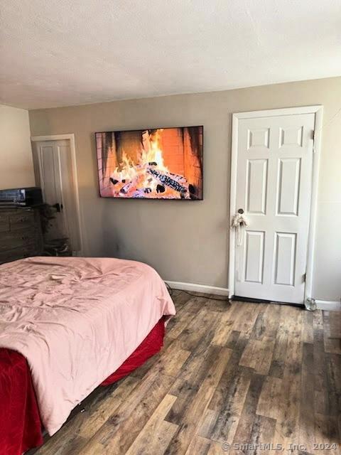 bedroom with a textured ceiling and dark hardwood / wood-style flooring