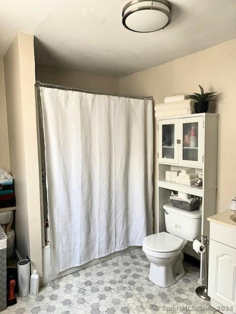 full bathroom with vanity, toilet, and tile patterned floors