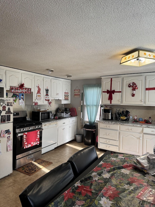 kitchen featuring appliances with stainless steel finishes, white cabinets, and tile patterned floors