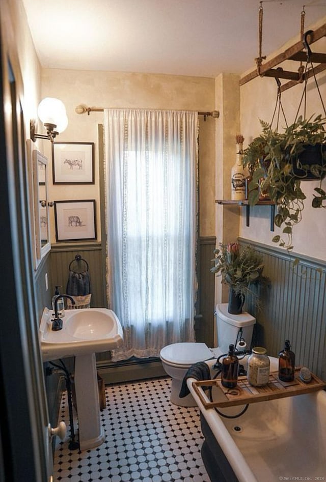 bathroom with toilet, sink, and a baseboard radiator