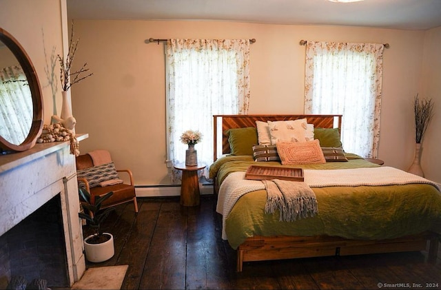 bedroom with baseboard heating, multiple windows, and dark hardwood / wood-style floors