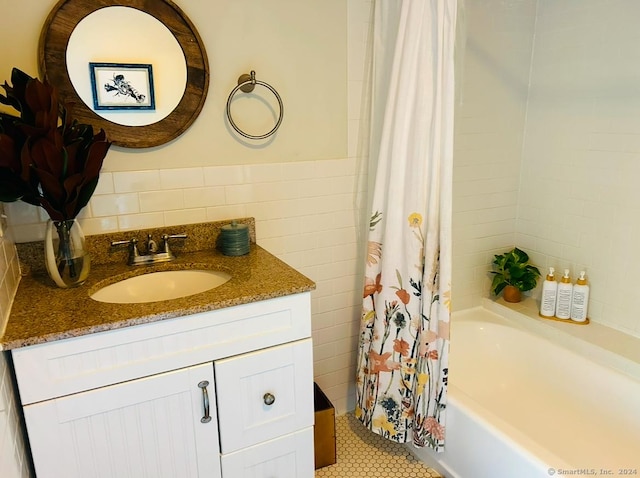 bathroom with vanity, tile patterned floors, tile walls, and shower / bath combo with shower curtain