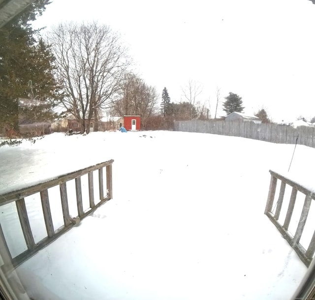 yard covered in snow featuring fence