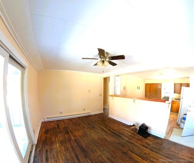 unfurnished living room with a baseboard heating unit, dark wood-type flooring, ceiling fan, and baseboards