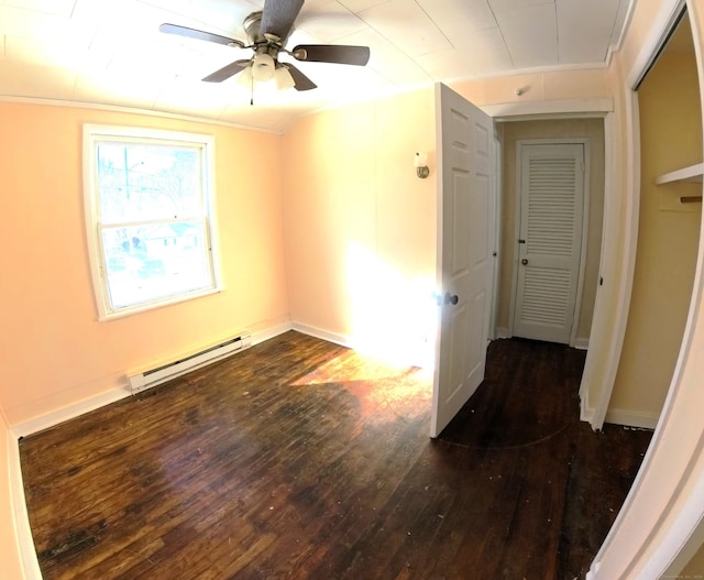 unfurnished room with baseboards, dark wood finished floors, a ceiling fan, ornamental molding, and a baseboard heating unit