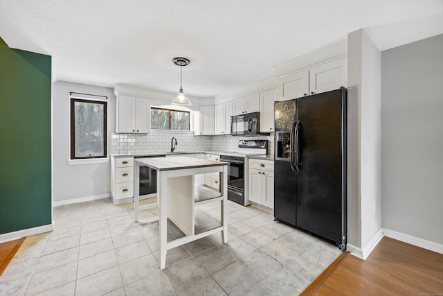 kitchen with black appliances, decorative light fixtures, a center island, and white cabinets