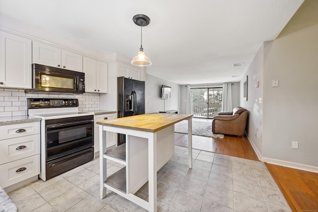 kitchen with white cabinetry, wood counters, light hardwood / wood-style floors, a breakfast bar, and black appliances