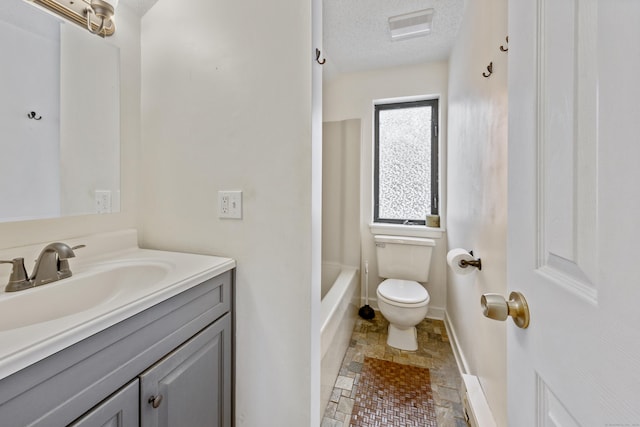 bathroom with vanity, a textured ceiling, and toilet