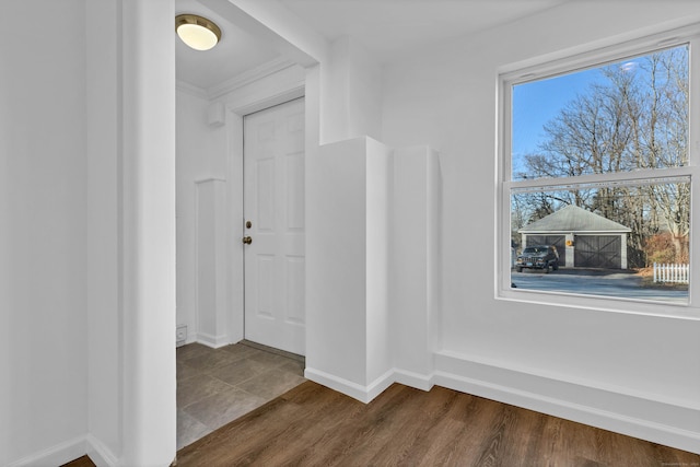 hallway with dark hardwood / wood-style flooring and ornamental molding