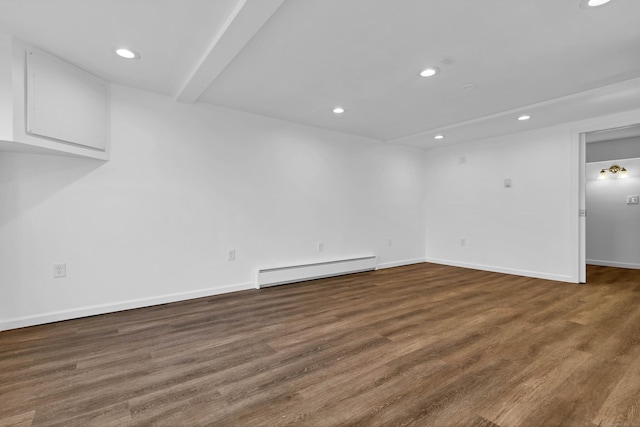 spare room with dark hardwood / wood-style flooring and baseboard heating