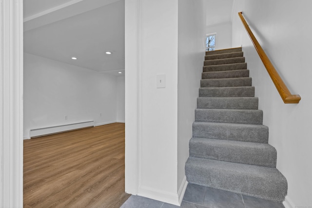 staircase featuring hardwood / wood-style floors and baseboard heating