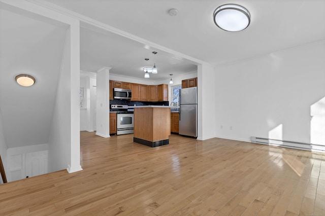 kitchen with hanging light fixtures, light hardwood / wood-style flooring, a baseboard heating unit, a kitchen island, and appliances with stainless steel finishes