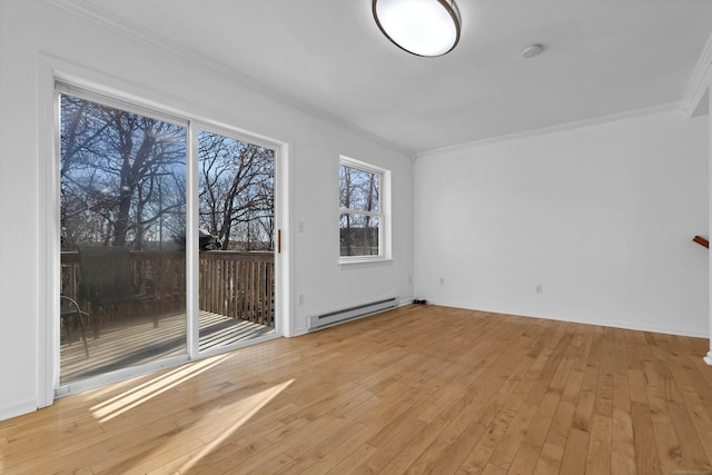 spare room featuring ornamental molding, baseboard heating, and light hardwood / wood-style flooring