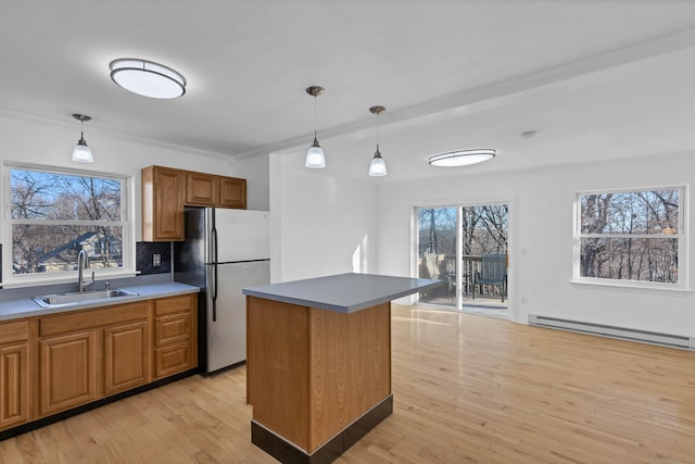 kitchen featuring sink, light hardwood / wood-style flooring, a baseboard heating unit, stainless steel fridge, and a kitchen island