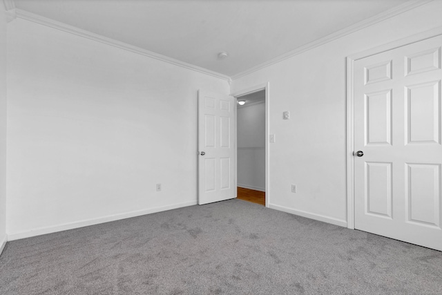 carpeted spare room featuring crown molding