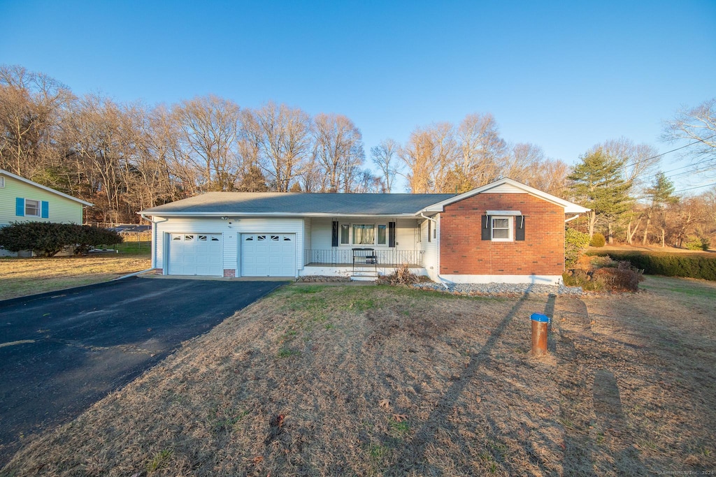 single story home featuring covered porch and a garage