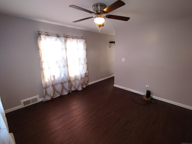 spare room featuring ceiling fan and dark wood-type flooring