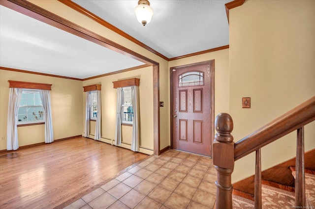 foyer entrance with ornamental molding, a textured ceiling, and light hardwood / wood-style flooring