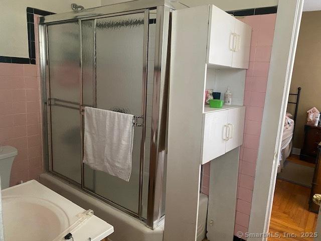 bathroom with tile walls, sink, and separate shower and tub