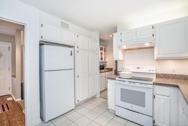 kitchen featuring white cabinets, light tile patterned floors, and white appliances