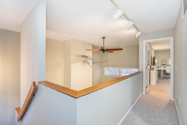 hallway with rail lighting and light colored carpet