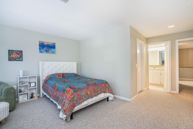 carpeted bedroom featuring ensuite bathroom and sink