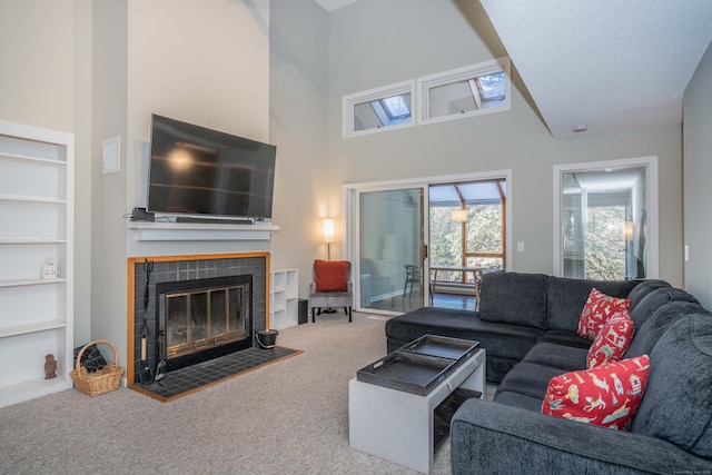 living room with carpet flooring, built in features, a fireplace, and a towering ceiling