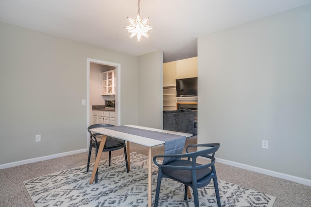 carpeted dining space featuring an inviting chandelier