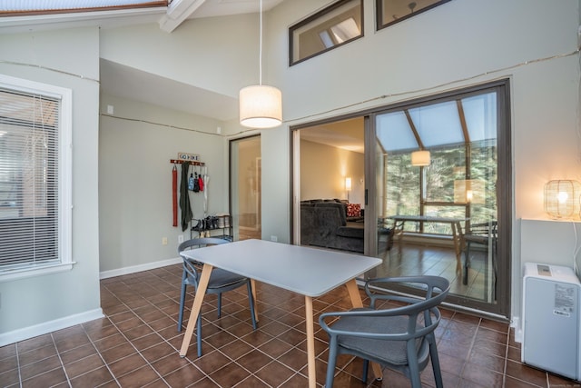 tiled dining space featuring high vaulted ceiling