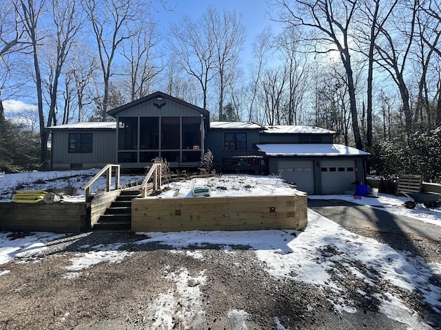 view of front of property with a garage and a sunroom