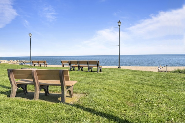 view of property's community featuring a lawn and a water view