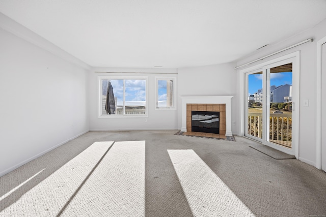 unfurnished living room featuring carpet and a tiled fireplace