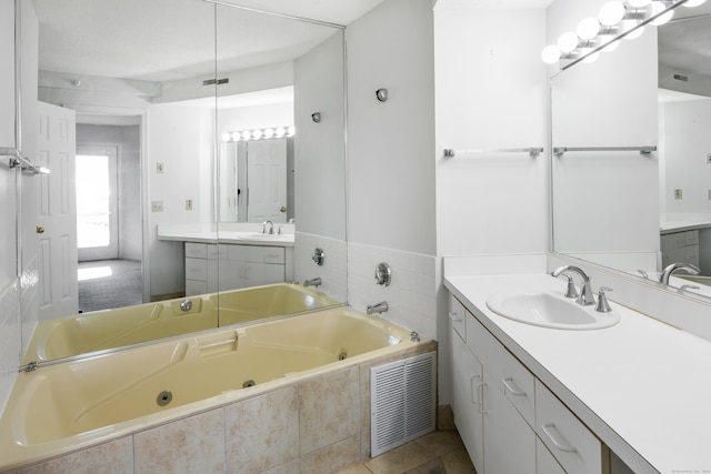 bathroom featuring vanity, tiled bath, and tile patterned floors