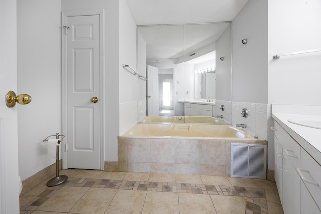 bathroom featuring vanity, tile patterned floors, and tiled tub