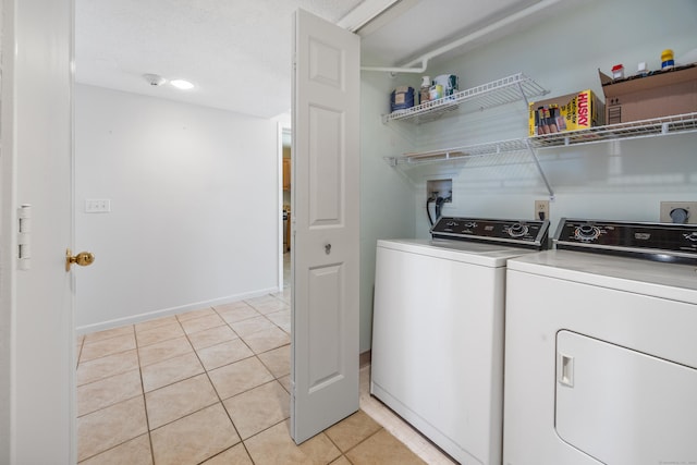 washroom with separate washer and dryer and light tile patterned flooring