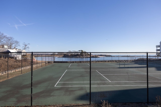 view of tennis court with a water view