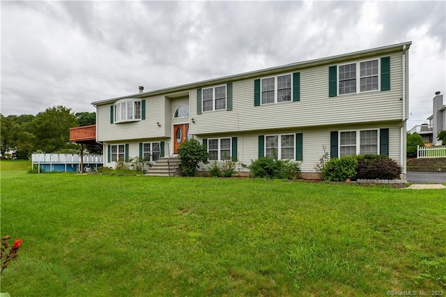 split foyer home with a swimming pool and a front lawn