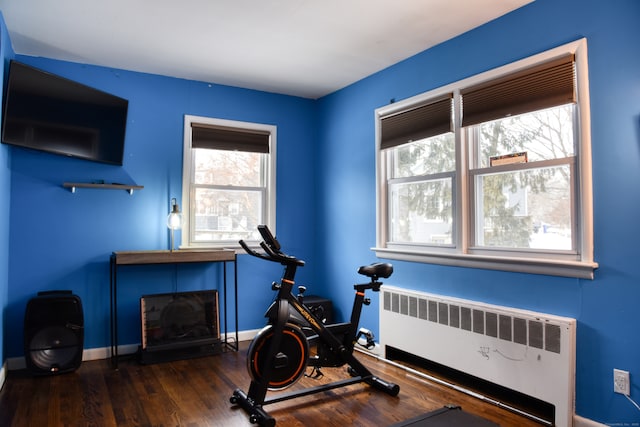 workout room with dark wood-type flooring and radiator