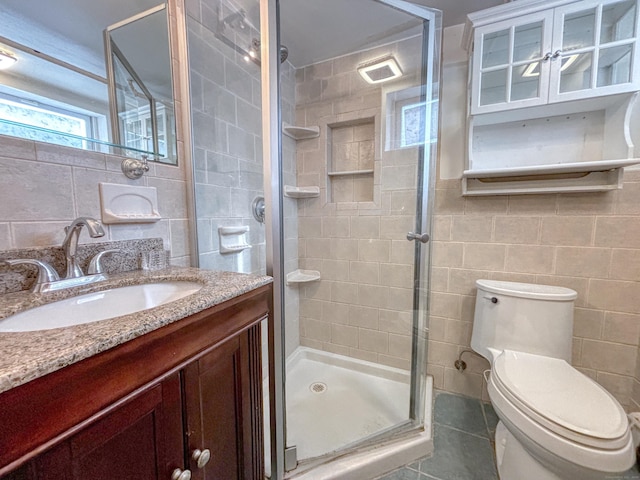 bathroom with tile patterned flooring, tile walls, an enclosed shower, and toilet