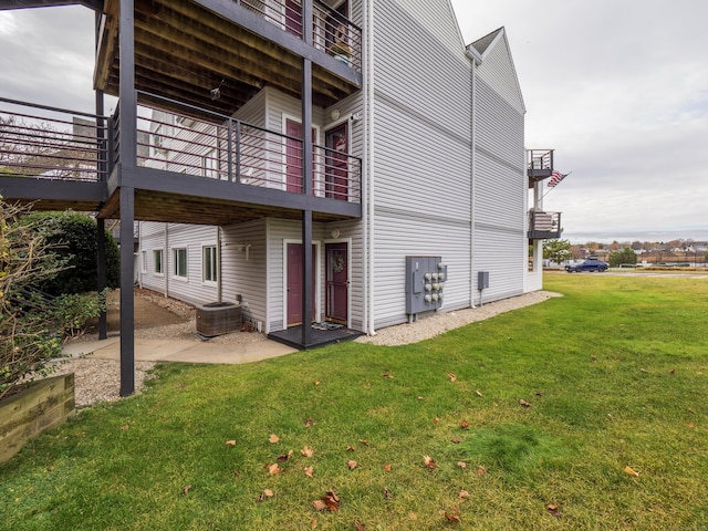 rear view of property featuring a patio area, cooling unit, and a yard