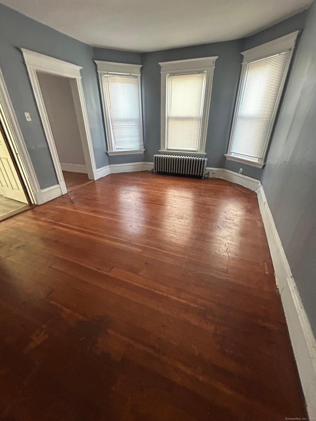 interior space with radiator heating unit and dark hardwood / wood-style floors