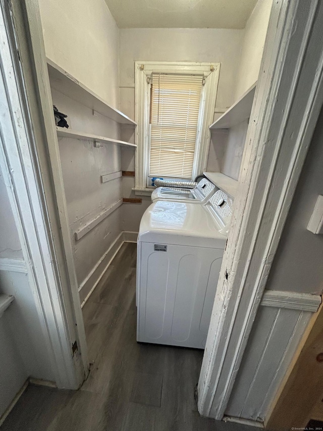 clothes washing area with dark hardwood / wood-style flooring and washing machine and dryer