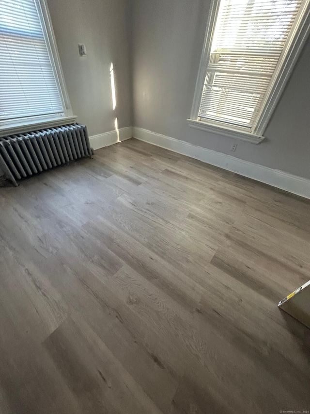 spare room with hardwood / wood-style flooring and radiator