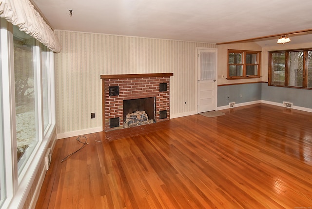 unfurnished living room with a fireplace, hardwood / wood-style flooring, and an inviting chandelier